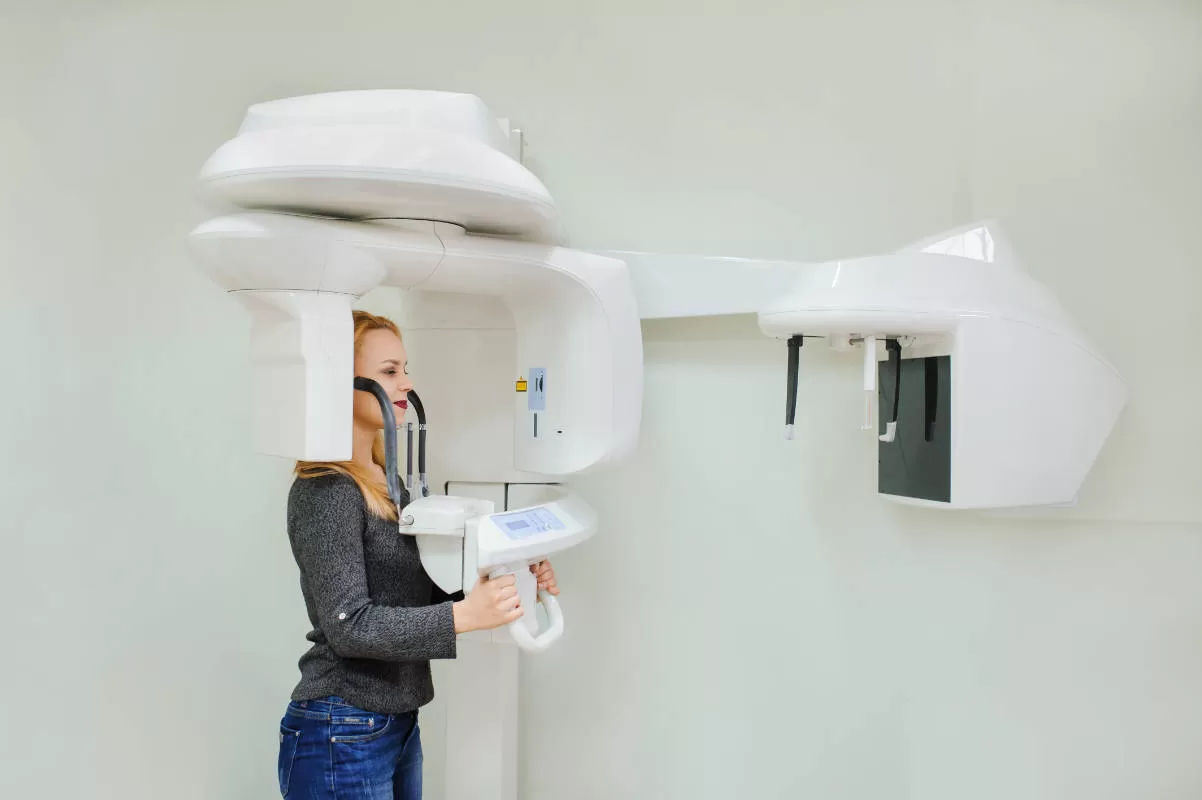donna sorridente si sottopone a radiografia dentale