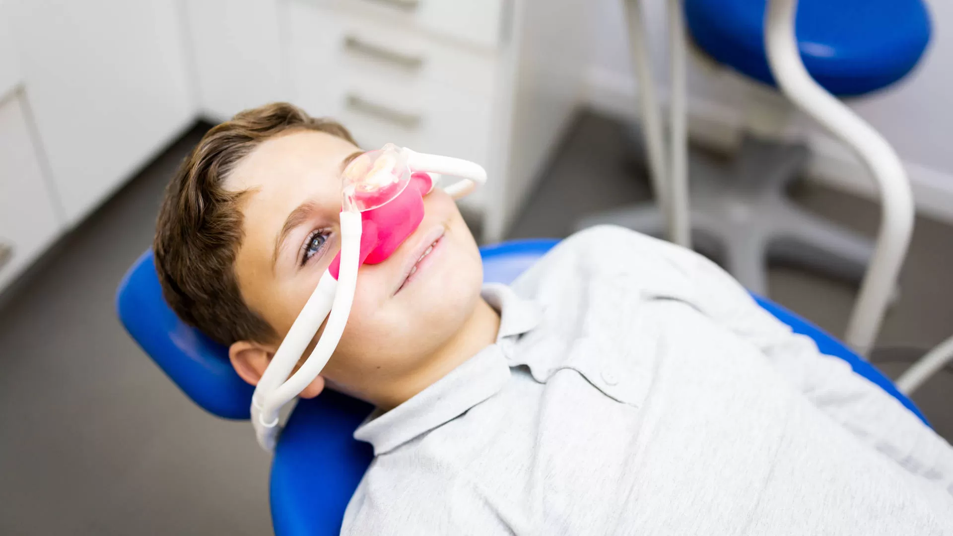 trattamento di sedazione cosciente con strumento di colore rosa su bambino tranquillo